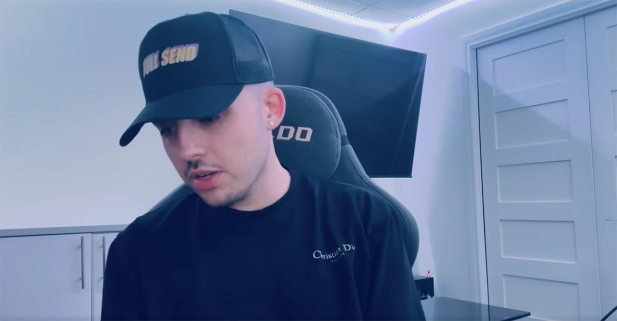 Dylan Demers portant une casquette noire &laquo; Full Send &raquo; et un t-shirt Christian Dior, assis devant un &eacute;cran dans une pi&egrave;ce blanche